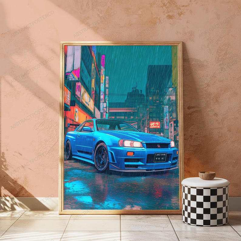 May include: A rectangular framed wall art print featuring a bright blue sports car parked on a wet city street at night. The scene is set against a backdrop of tall buildings with glowing neon signs and vertical Japanese text in a rainy atmosphere.