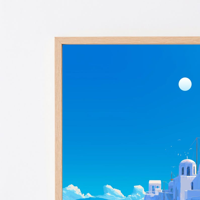 May include: A framed art print featuring a bright blue sky with a white circular moon above white buildings with domed roofs. The architecture is set against a clear sky with scattered white clouds at the base, all enclosed in a light wood frame.