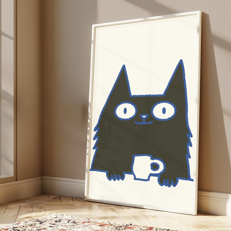 May include: A framed wall art print featuring a stylized black cat with large white eyes and a blue outline. The cat is depicted from the chest up, holding a small white mug with both paws against a cream-colored background in a simple graphic style.