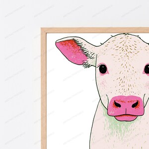 Peut inclure: Une impression d'art encadr&eacute;e repr&eacute;sentant une illustration stylis&eacute;e de t&ecirc;te de veau. Le veau a un pelage cr&egrave;me clair avec des d&eacute;tails en lignes brunes, de grands yeux noirs, ainsi qu'un museau et un int&eacute;rieur d'oreille rose vif. Cadre en bois clair.