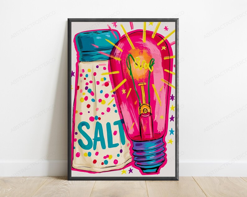 May include: A framed art print featuring a white salt shaker with a blue cap and colorful confetti dots, labeled with the word SALT in blue. Next to it is a bright pink light bulb with yellow rays and small stars, all in a vibrant pop art style.