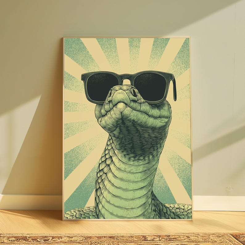 May include: A vertical rectangular wall art print featuring a detailed illustration of a green snake wearing black sunglasses. The background consists of a light yellow and teal sunburst pattern with a textured, vintage-inspired graphic design.