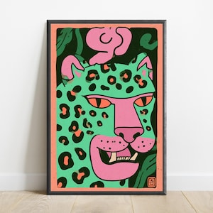 May include: A framed rectangular art print featuring a stylized leopard illustration. The leopard has a mint green face with black spots, a pink snout, and orange eyes. It is set against a dark green background with a coral pink border.