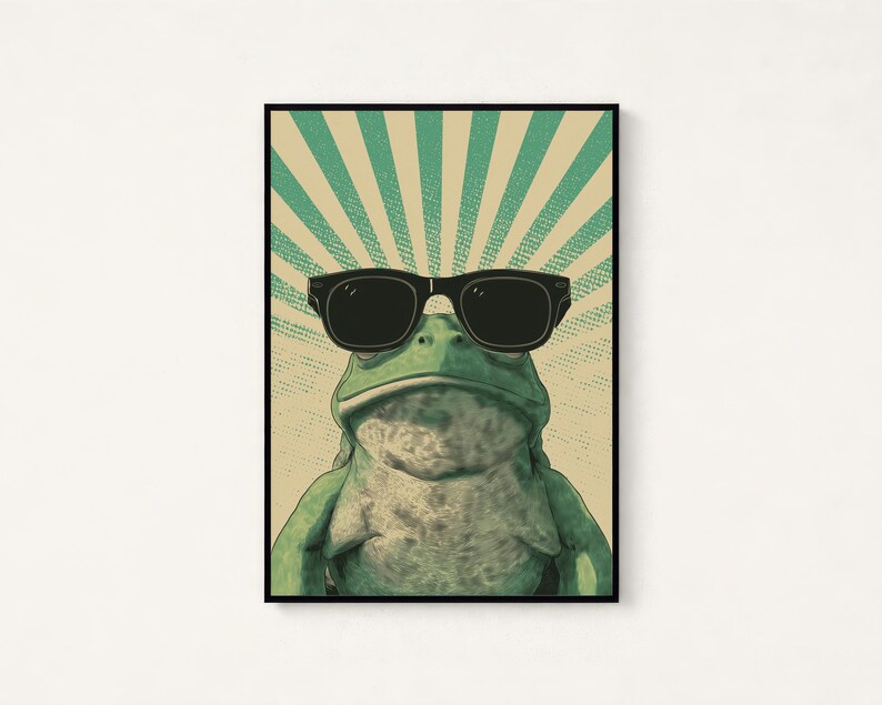 K&ouml;nnte beinhalten: Ein gerahmter Wandkunstdruck, der einen gr&uuml;nen Frosch mit einer schwarzen Sonnenbrille zeigt. Der Hintergrund besteht aus einem beigen und blaugr&uuml;nen Sonnenstrahlenmuster mit einer gepunkteten Textur. Der Frosch ist mittig platziert.