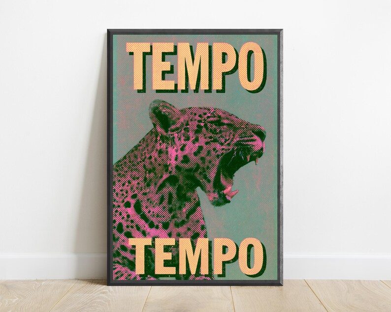Pu&ograve; includere: Una stampa artistica rettangolare incorniciata raffigurante un leopardo ruggente in punti mezzatinta rosa e neri su uno sfondo verde acqua tenue. La parola TEMPO &egrave; stampata in grandi lettere maiuscole arancioni chiare in alto e in basso.