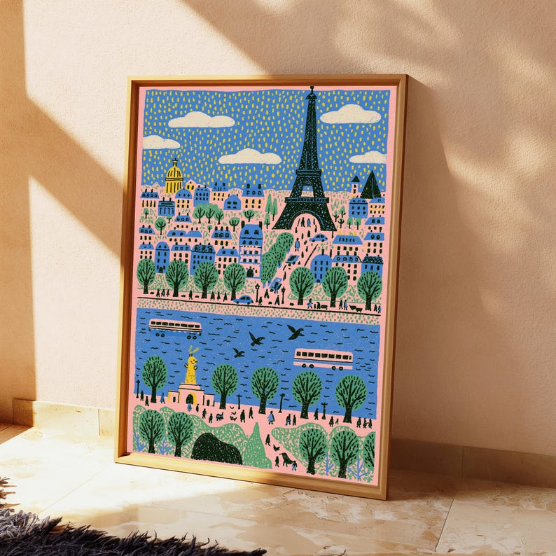 K&ouml;nnte beinhalten: Ein gerahmter Kunstdruck mit einer stilisierten Illustration der Pariser Skyline, der Eiffelturm, einem blauen Fluss, gr&uuml;nen B&auml;umen und Geb&auml;uden. Die Szene zeigt kleine Figuren, Busse und wei&szlig;e Wolken vor einem gelb gepunkteten blauen Himmel.