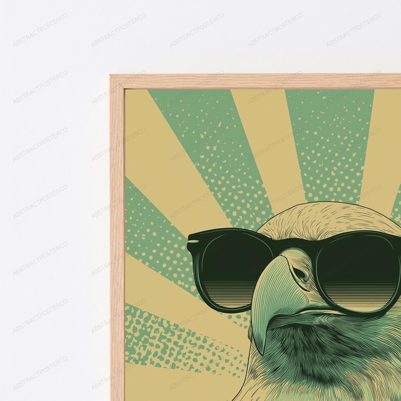 May include: A framed wall art print featuring a stylized illustration of an eagle wearing black sunglasses. The background consists of alternating light yellow and green sunburst rays with a dotted texture pattern throughout the design.