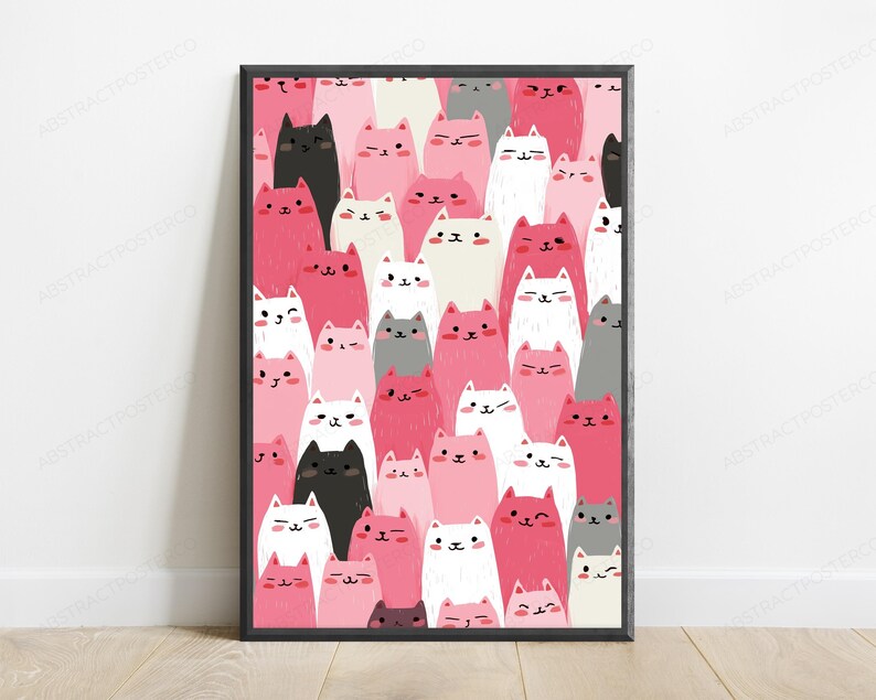 May include: A rectangular framed wall art print featuring a dense, repeating pattern of stylized cartoon cats in various shades of pink, white, black, and gray. Each cat has a simple face with small eyes, a tiny nose, and a mouth, arranged vertically.