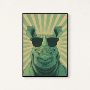 May include: A framed art print featuring a green rhinoceros wearing black sunglasses. The rhino is smiling, set against a background of green and tan radial stripes. The artwork has a vintage, illustrative style.