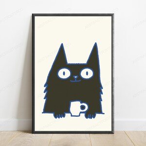 May include: A framed wall art print featuring a stylized black cat with wide white eyes and a blue outline. The cat is depicted from the chest up, holding a small white mug with both paws. The background of the illustration is a solid cream color.