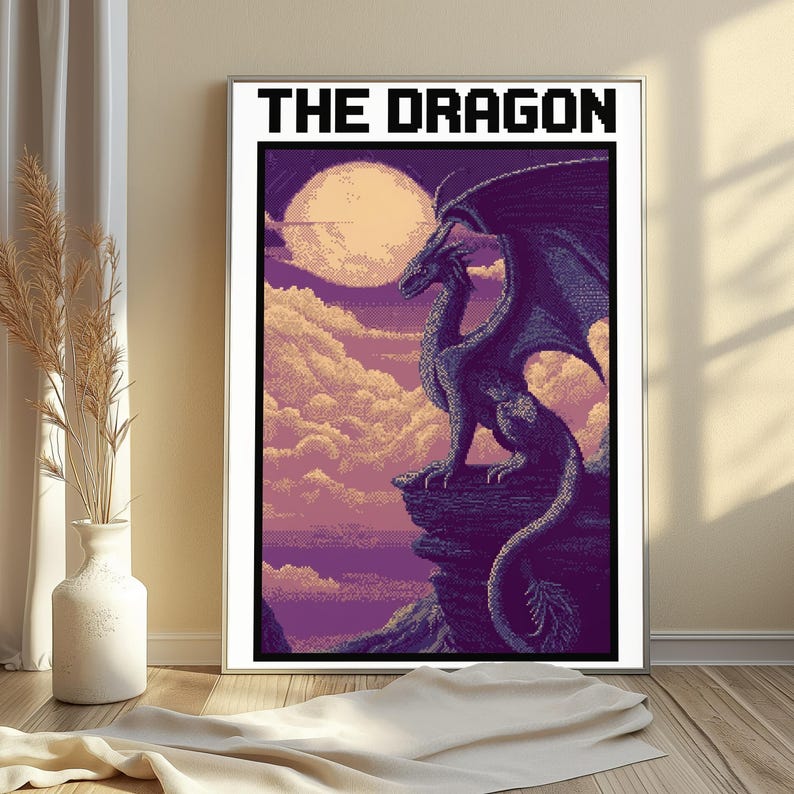 May include: A framed wall art print titled THE DRAGON in a pixel art style. The image depicts a dark purple dragon perched on a rocky cliff edge against a backdrop of a large pale moon, soft clouds, and a purple sky. The artwork is rectangular.