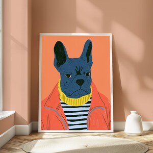 K&ouml;nnte beinhalten: Ein gerahmter Kunstdruck, der eine dunkelblaue Franz&ouml;sische Bulldogge mit einem gelben Rollkragenpullover unter einer leuchtend orangefarbenen Jacke zeigt. Der Hund ist vor einem einfarbigen orangefarbenen Hintergrund zentriert.