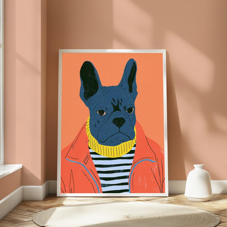 K&ouml;nnte beinhalten: Ein gerahmter Kunstdruck, der eine dunkelblaue Franz&ouml;sische Bulldogge mit einem gelben Rollkragenpullover unter einer leuchtend orangefarbenen Jacke zeigt. Der Hund ist vor einem einfarbigen orangefarbenen Hintergrund zentriert.