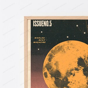 May include: A framed wall art print featuring a dark background with a large orange moon and small white stars. The text ISSUENO.5 and WORLDS BEST MAGAZINE are printed in white. The design has a textured, dotted halftone effect throughout.