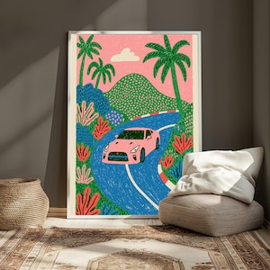 May include: A framed art print featuring a pink sports car driving along a winding blue road. The scene includes green palm trees, pink coral-like plants, a textured green mountain, and a single white cloud against a solid pink sky background.