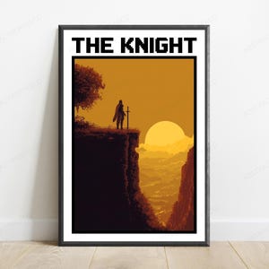May include: A framed poster titled THE KNIGHT featuring a pixel art illustration of a lone figure standing on a cliff edge with a sword at sunset. The scene uses shades of orange and dark brown to depict a silhouette against a large sun.