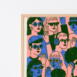 May include: A framed art print featuring a stylised illustration of a crowd of people in a vibrant colour palette of pink, blue, and dark green. The figures are depicted with bold outlines, wearing sunglasses and hats, with some raising their hands.