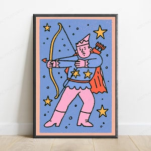 May include: A framed wall art print featuring a cartoon archer character with a pink hat, shirt, and pants, wearing a red cape. The character holds a yellow bow and arrow against a blue background filled with yellow stars and black dots.