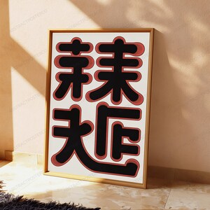 May include: A rectangular framed wall art piece featuring a white background with four large, bold black Chinese characters arranged in a two-by-two grid. Each black character is outlined with a thick, textured red border with subtle hatching.