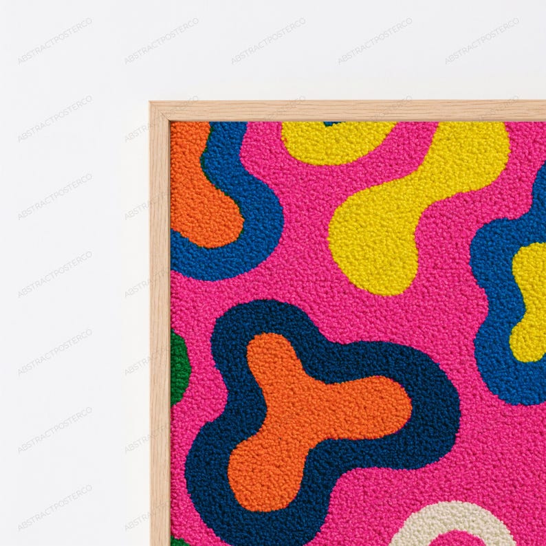 May include: A framed wall art piece featuring a textured, tufted surface with an abstract pattern of organic, amoeba-like shapes in vibrant shades of hot pink, bright yellow, orange, deep navy blue, and a small section of cream.