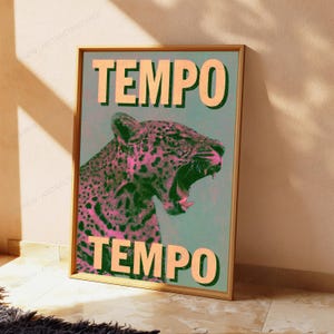 Pu&ograve; includere: Una stampa artistica da parete rettangolare in una cornice di legno raffigurante un leopardo stilizzato con un motivo a mezzitoni rosa e nero su sfondo verde acqua. La parola TEMPO &egrave; stampata in grandi lettere arancioni chiare in alto e in basso.