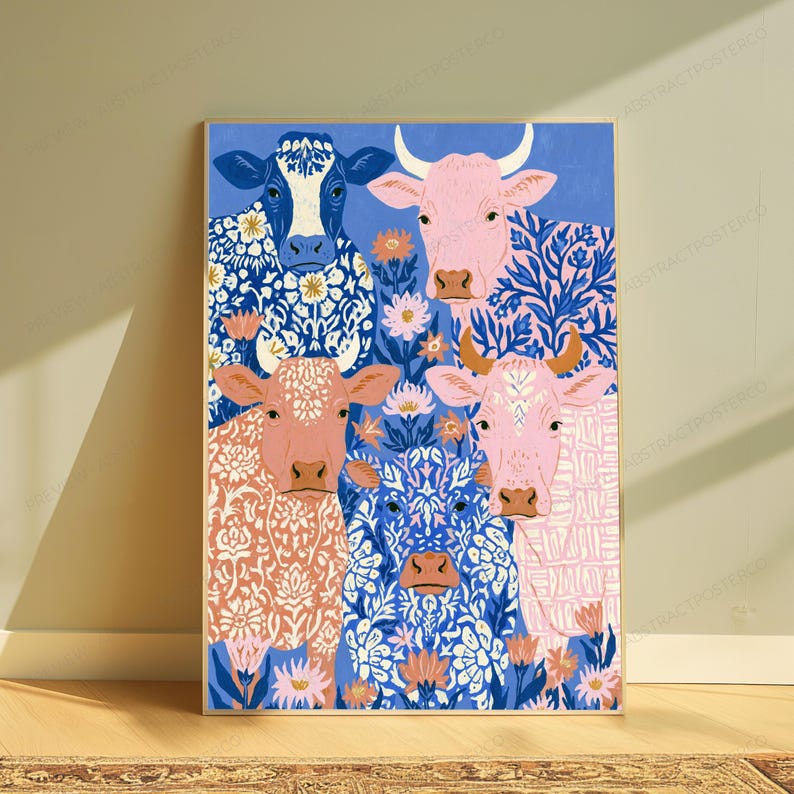 May include: A rectangular wall art print featuring four cows arranged in a grid. The cows are rendered in shades of blue, pink, and peach, each decorated with intricate white floral and botanical patterns against a solid blue background.
