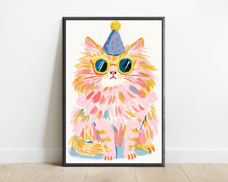 K&ouml;nnte beinhalten: Ein gerahmter Kunstdruck, der eine flauschige Katze mit langem rosa und orangefarbenem Fell zeigt. Die Katze tr&auml;gt einen blauen Partyhut mit roten Punkten und eine gelb umrandete Sonnenbrille. Das Bild zeigt deutlich sichtbare Pinselstriche.