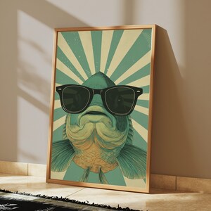 May include: A rectangular framed wall art print featuring a stylised illustration of a fish wearing black sunglasses. The background consists of alternating teal and cream-coloured sunburst rays radiating from the centre behind the fish.