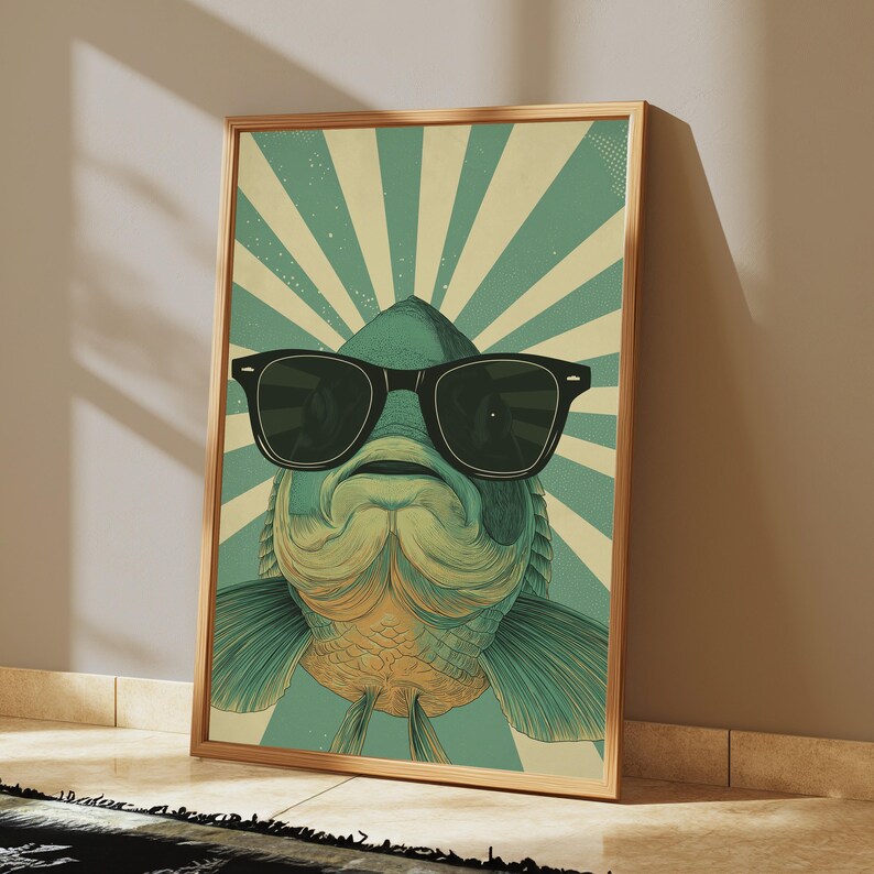May include: A rectangular framed wall art print featuring a stylised illustration of a fish wearing black sunglasses. The background consists of alternating teal and cream-coloured sunburst rays radiating from the centre behind the fish.