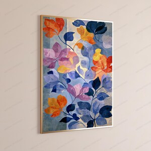 Puede incluir: Una impresi&oacute;n de arte mural rectangular vertical en un marco dorado fino que presenta una ilustraci&oacute;n bot&aacute;nica de flores y hojas estilizadas en tonos naranja, amarillo, morado y azul oscuro sobre un fondo azul claro y crema.