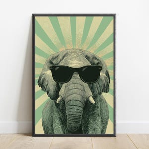May include: A framed wall art print featuring a detailed illustration of a grey elephant wearing black sunglasses. The elephant is centred against a background of alternating light green and cream-coloured sunburst rays with a dotted texture.