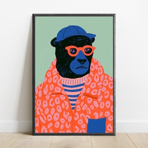 May include: A framed art print featuring a black panther wearing a blue baseball cap, bright orange glasses, a blue and pink striped sweater, and an orange leopard print jacket with a blue pocket, set against a solid light green background.