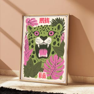 Peut inclure: Une impression d'art encadr&eacute;e repr&eacute;sentant un l&eacute;opard vert stylis&eacute; aux yeux roses, la gueule ouverte, entour&eacute; de feuilles tropicales roses et vert fonc&eacute;. L'&oelig;uvre comporte des caract&egrave;res chinois roses en haut et en bas de la composition.