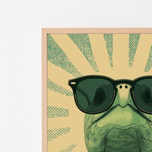 K&ouml;nnte beinhalten: Ein gerahmter Wandkunstdruck, der eine gr&uuml;ne Schildkr&ouml;te mit dunkelgr&uuml;ner Sonnenbrille zeigt. Der Hintergrund besteht aus einem hellgelben Sonnenstrahlenmuster mit gr&uuml;nen, gepunkteten Strahlen, die von der Mitte nach au&szlig;en strahlen.
