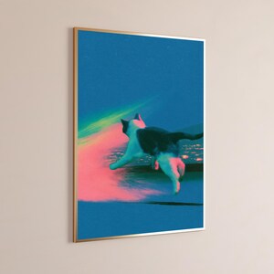 May include: A framed vertical wall art print featuring a black and white cat leaping across a dark blue background. The cat is illuminated by a vibrant, glowing pink and green light streak that extends across the composition, creating a high-contrast effect.