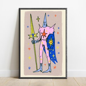 May include: A framed art print featuring a stylised figure in a pink suit with a pointed hood, holding a long yellow spear with a blue eye emblem. The figure wears a blue cape and carries a blue shield with a yellow star, set against a beige background.