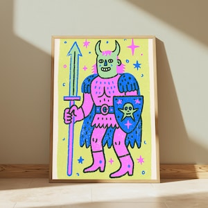 May include: A framed art print featuring a stylized illustration of a horned figure in pink armor, holding a blue sword and a blue shield with a skull emblem. The background is light green with scattered pink and blue stars and small circles.