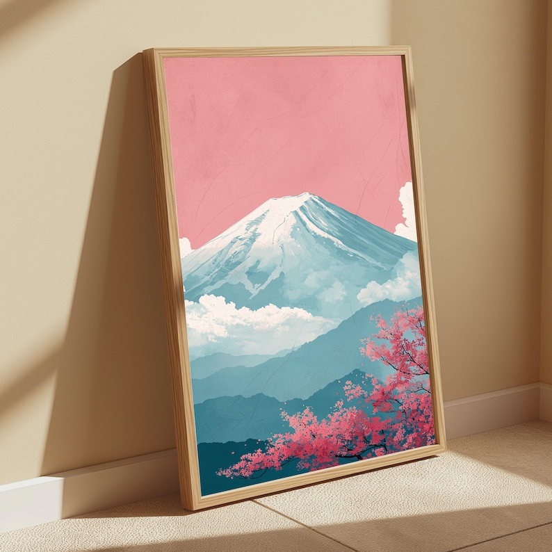 May include: Framed art print featuring a serene Japanese landscape. The artwork depicts Mount Fuji with a snow-capped peak, set against a pink sky and blue mountains. Cherry blossoms in full bloom add a pop of pink.