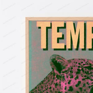 May include: A framed wall art print featuring the partial text TEMP in large, light yellow, dotted letters against a dark green background. Below the text, a stylized leopard head is depicted in a pink and dark green halftone dot pattern.