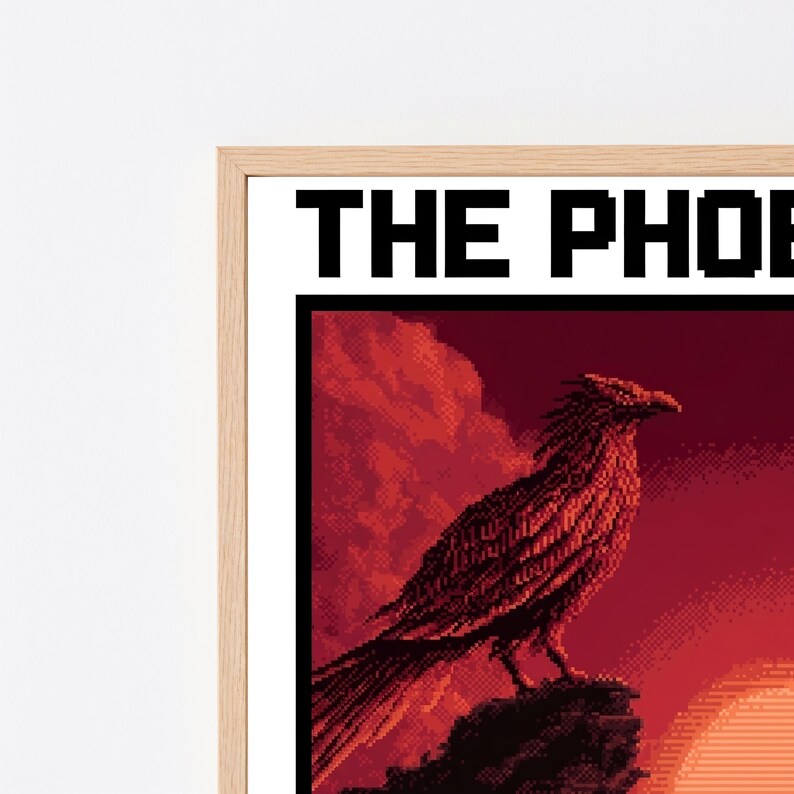 Puede incluir: Una impresi&oacute;n de arte en p&iacute;xeles enmarcada que muestra un p&aacute;jaro grande posado sobre una roca frente a un atardecer rojo intenso. El texto THE PHOE es visible en la parte superior con una fuente pixelada negra. El marco es de madera clara.