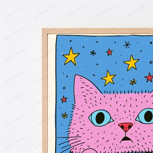 Pu&ograve; includere: Una stampa artistica incorniciata raffigurante un gatto rosa stilizzato con grandi occhi azzurri su uno sfondo blu brillante pieno di stelle gialle e rosse. Il gatto presenta dettagli a linee nere per la texture del pelo e un naso rosso.