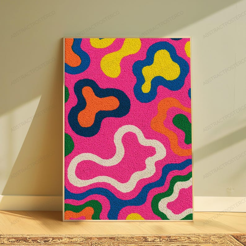 May include: A rectangular wall art print featuring a vibrant, textured pattern of irregular, amoeba-like shapes in bright yellow, orange, green, and white, all set against a bold, saturated hot pink background with a distinct, grainy surface.