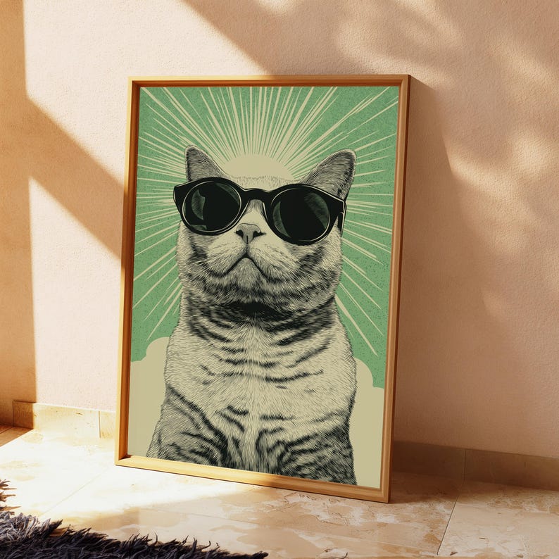 May include: A framed vertical wall art print featuring a stylized illustration of a tabby cat wearing black sunglasses. The cat is centered against a light green background with radiating white sunburst lines and a cream-colored base area.