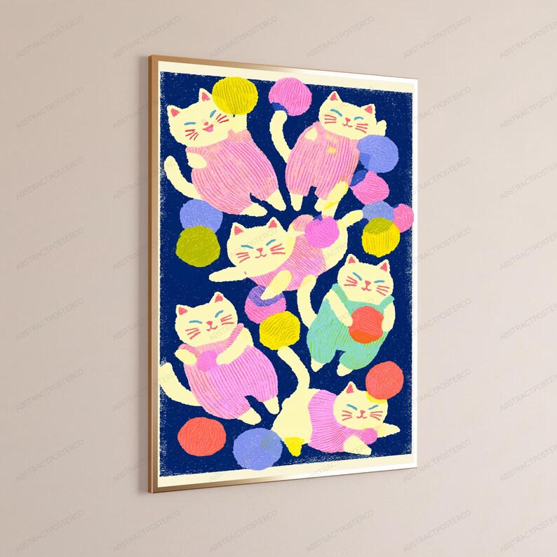May include: A framed wall art print featuring a dark blue background with six cream-colored cats wearing pink or light green overalls. The cats are depicted playing with various colorful yarn balls in shades of yellow, pink, blue, and orange.