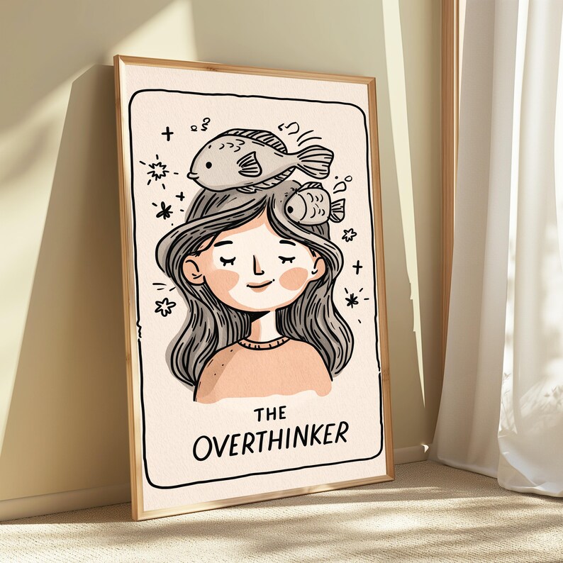 K&ouml;nnte beinhalten: Ein gerahmter Kunstdruck mit einer Cartoon-Illustration einer Person mit langem, welligem Haar und zwei Fischen auf dem Kopf. Der Hintergrund ist cremefarben mit kleinen Sternakzenten. Darunter steht der Text THE OVERTHINKER.