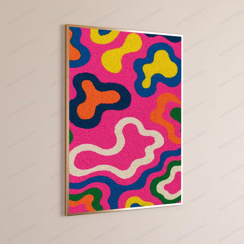 May include: A rectangular wall art piece featuring a textured, tufted surface with a vibrant pattern of organic, amoeba-like shapes in bright pink, yellow, orange, dark blue, green, and cream, all enclosed within a thin, metallic gold frame.
