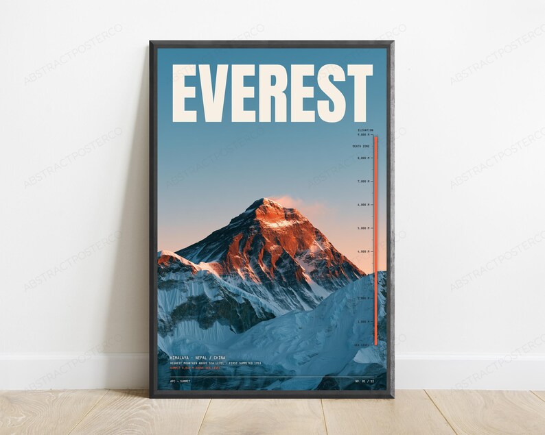 Op de afbeelding: Een ingelijste wandposter met een foto van de Mount Everest met de tekst EVEREST in grote witte letters bovenaan. De afbeelding toont een besneeuwde bergtop bij zonsondergang met een verticale rode hoogteschaal aan de rechterkant.