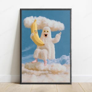 K&ouml;nnte beinhalten: Ein gerahmter Wandkunstdruck mit einem flauschigen wei&szlig;en Wesen mit gelben Augen und einem breiten L&auml;cheln, das zwischen Wolken an einem blauen Himmel schwebt. Das Wesen h&auml;lt eine gro&szlig;e gelbe Banane mit l&auml;chelndem Gesicht und tr&auml;gt hellrosa Ballettschuhe.