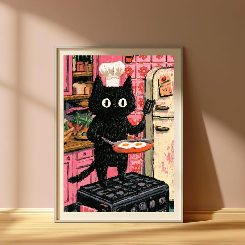 Peut inclure: Une impression d'art encadr&eacute;e repr&eacute;sentant un chat noir portant une toque de chef blanche, debout sur une cuisini&egrave;re noire dans une cuisine rose. Le chat tient une po&ecirc;le avec deux &oelig;ufs au plat et une spatule noire. Cuisine avec meubles roses.