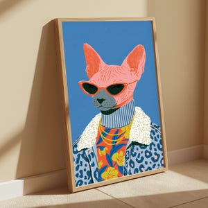 Puede incluir: Una l&aacute;mina art&iacute;stica enmarcada que presenta una ilustraci&oacute;n estilizada de un gato Sphynx rosa con gafas de sol de ojo de gato rojas, un cuello alto azul claro y una chaqueta con estampado de leopardo azul con cuello de borreguito blanco sobre una camisa floral.